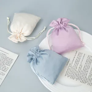 Elegant satin drawstring pouches for jewelry storage in pastel blue, purple and white