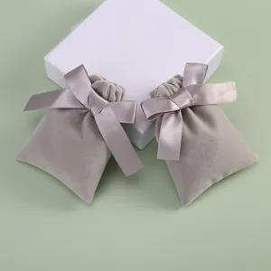 Detailed view of soft gray velvet drawstring jewelry pouches with silk ribbon bows