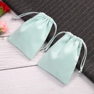 Detalle de dos pequeñas bolsas de terciopelo azul claro con cordón para joyas.