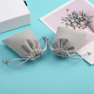 Vue détaillée de la texture des pochettes en velours gris avec cordon coulissant