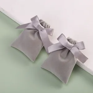 Detail view of premium grey velvet jewelry storage pouches with elegant ribbon bows