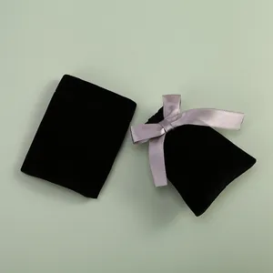 Vue détaillée de pochettes à bijoux en velours noir avec un élégant nœud en soie.