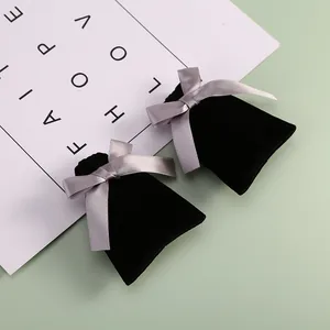 Vue détaillée de pochettes à bijoux en velours noir avec des nœuds en ruban de satin