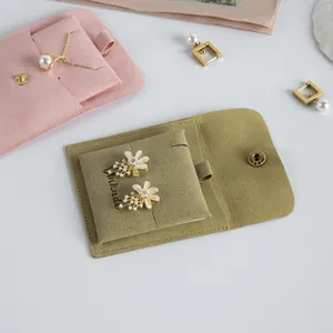 Detail of soft suede jewelry pouch insert holding elegant floral pearl earrings