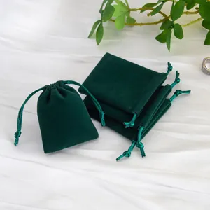 Primer plano de elegantes bolsitas de terciopelo verde oscuro con cordón para joyas