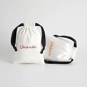 Par de bolsas blancas para joyas con cordón, cintas negras y detalle de logotipo