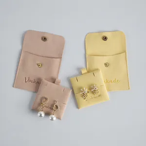 Close-up of premium suede jewelry pouches with snap buttons and matching earring pads