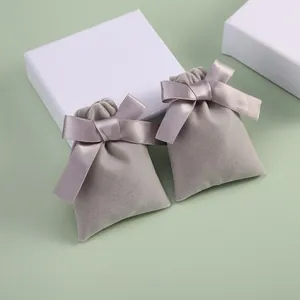 Elegant grey velvet drawstring jewelry pouches with silk ribbon bows for gift packaging