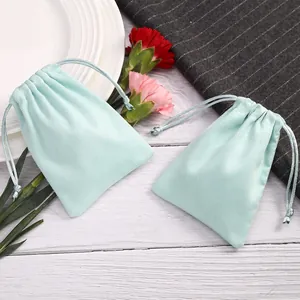 Detalle de dos bolsas de terciopelo azul claro con cordón para empaque de joyería