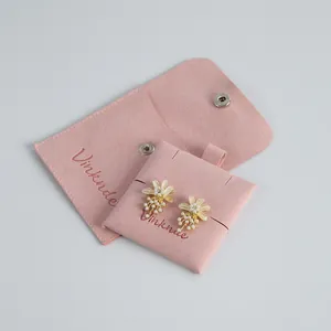 Soft pink velvet jewelry pouch with snap button and elegant floral pearl earrings