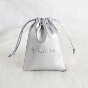 Close-up of a silver PU leather pouch showing the textured finish and drawstring.