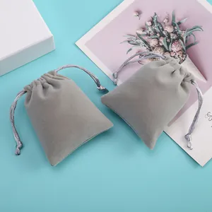 Gros plan de deux pochettes en velours gris avec cordon pour le rangement de bijoux de luxe