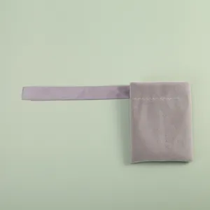 Detailed close-up of a plush grey velvet jewelry pouch with soft lavender ribbon strap