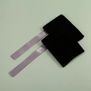 Vue détaillée de pochettes à bijoux en velours noir avec rubans de satin lavande.