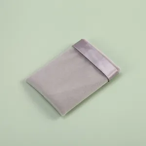 Close-up detail showing the soft texture of grey velvet pouch with elegant satin ribbon trim
