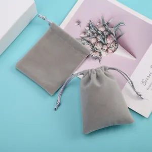 Vue détaillée de deux petits sacs en velours gris avec cordon pour bijoux et cadeaux