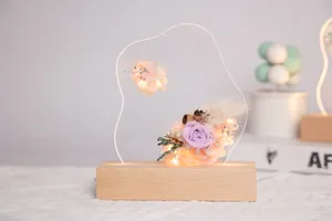 Gros plan d'une veilleuse en acrylique avec fleurs éternelles sur socle en bois
