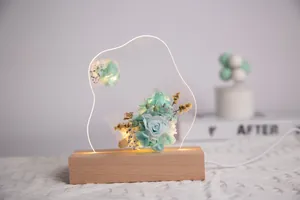 Vue détaillée de roses bleues éternelles dans une veilleuse LED en acrylique avec bois
