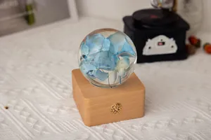 Détail d'un spécimen d'hydrangée bleue dans une veilleuse en cristal et bois