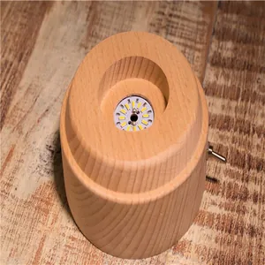 Macro detail view of internal circular LED light board on wooden music box base.