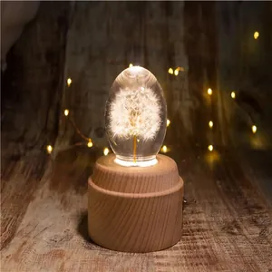 Dettaglio carillon a sfera di cristallo con tarassaco luminoso e base in legno