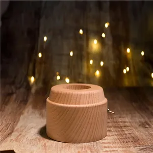 Close-up of a natural wooden rotating music box base with a metal toggle switch.