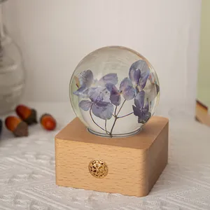 Veilleuse boule de cristal avec hortensia séché et base en bois pour décoration de table