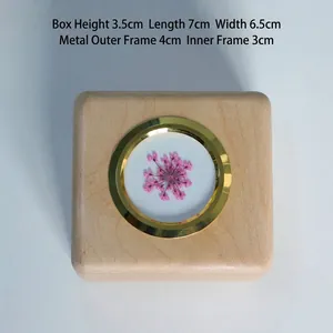 Detailed view of square wooden storage box for first hair with pink flower detail
