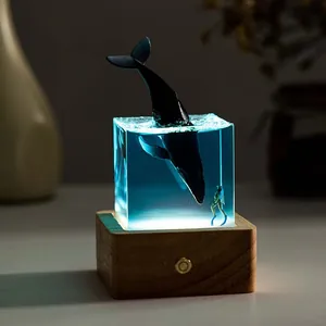 Detailed view of resin ocean whale night light featuring jumping whale and diver