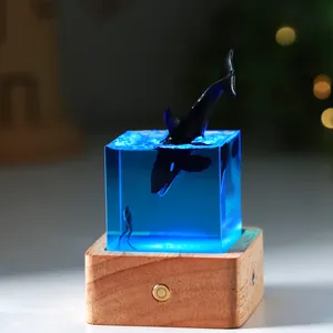 Close-up of a resin ocean cube night light featuring a diving orca and a scuba diver.