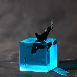 Resin micro-landscape ornament featuring a jumping orca and a diver in a blue sea cube.