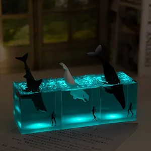 Detail view of glowing miniature ocean whale resin night light cubes with blue internal LED light