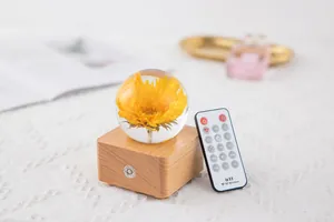 Detailed view of sunflower crystal ball music box with remote control and wooden base