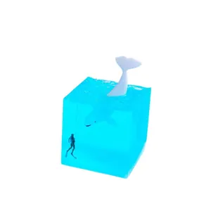 Minimalist blue resin ocean night light featuring a miniature whale and diver