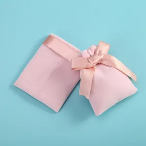 Pochettes à bijoux en velours rose avec nœud en satin sur fond bleu, lot de deux