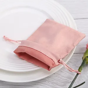Detaillierte Nahaufnahme des rosa Wildleder-Schmuckbeutels mit Kordelzug auf Teller