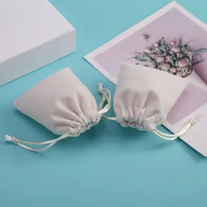 Detalle de elegantes bolsas de terciopelo beige con cordón para joyas y regalos
