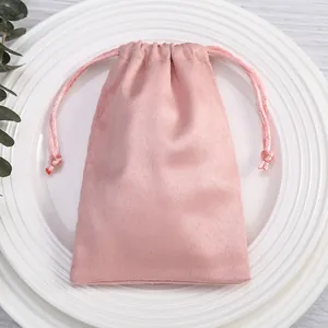 Nahaufnahme des rosa Wildleder-Schmuckbeutels mit weicher Stofftextur und Kordelzug