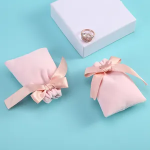 Détail macro du sac à bijoux en velours rose avec nœud élégant en satin