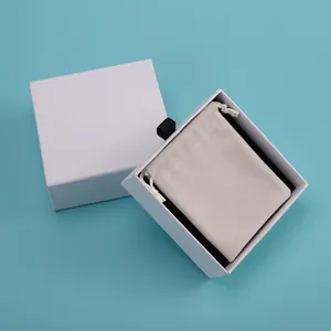 Vista detallada de la caja de joyas blanca con bolsa de terciopelo beige de alta calidad
