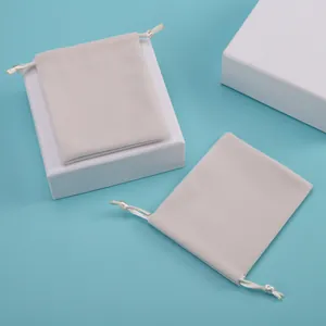 Primer plano de elegantes bolsas de terciopelo beige con cordón para empaque de joyas