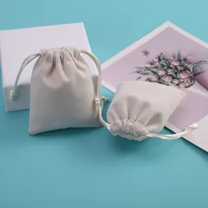 Detalle de las bolsas de terciopelo beige con cordón para joyas y embalaje de regalos