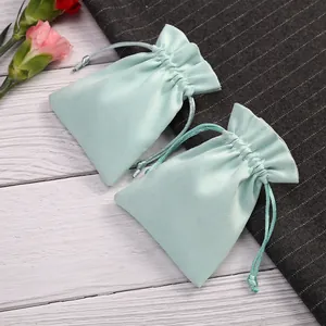 Primer plano de bolsitas de terciopelo verde menta para joyas en fondo decorativo