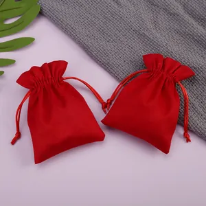 Primer plano de dos bolsas de terciopelo rojo con cordón para joyas y artículos pequeños