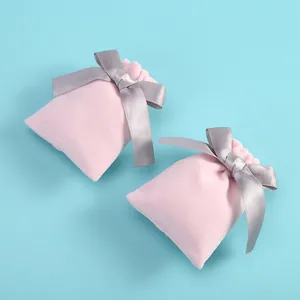 Deux pochettes en velours rose avec nœuds en satin gris pour bijoux