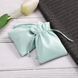 Detalle de la textura suave de las bolsas de terciopelo verde menta para joyas con cordón