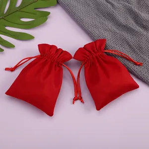 Primer plano de pequeñas bolsas de terciopelo rojo con cordón para joyas y regalos