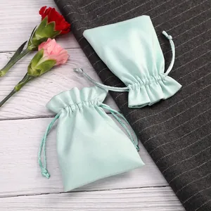 Detalle de la bolsa de joyería de terciopelo verde menta con cordón y textura suave