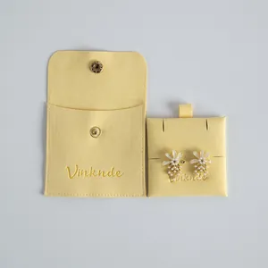Yellow velvet jewelry pouch with snap closure and elegant floral pearl earrings