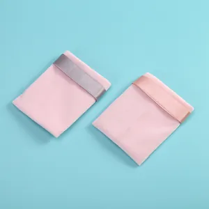 Détail de pochettes à bijoux en velours rose avec fermetures à ruban sur fond bleu ciel